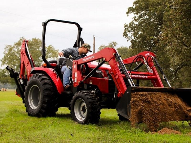 Man using a 2020 Mahindra 2600 Series tractor to move dirt